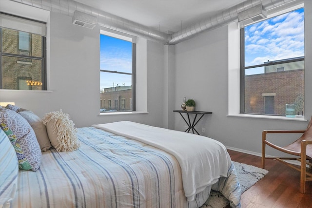 bedroom with a fireplace and hardwood / wood-style flooring