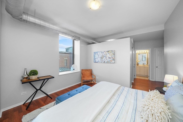 bedroom featuring ensuite bath and hardwood / wood-style flooring