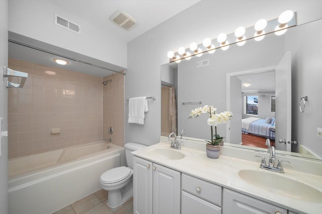 full bathroom with vanity, tiled shower / bath combo, tile patterned floors, and toilet