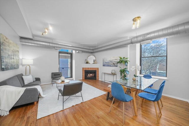 living room with track lighting, a tiled fireplace, and hardwood / wood-style floors