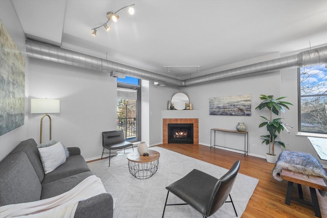 living room featuring a tiled fireplace and light wood-type flooring