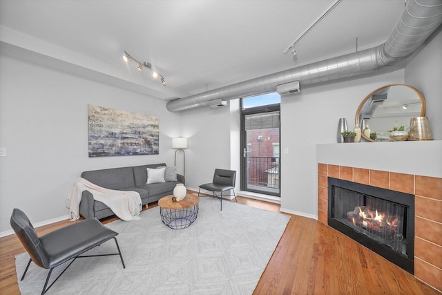 living room featuring a tile fireplace and wood-type flooring