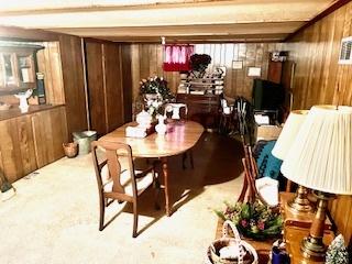 dining area with carpet floors and wood walls