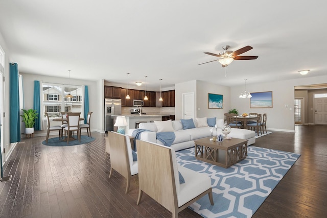 living room featuring dark hardwood / wood-style flooring and ceiling fan with notable chandelier