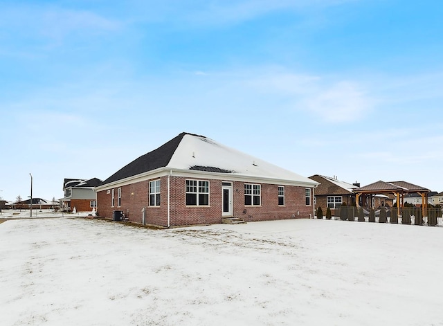 snow covered back of property with a gazebo