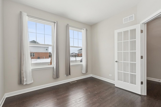 empty room featuring dark hardwood / wood-style flooring and a wealth of natural light