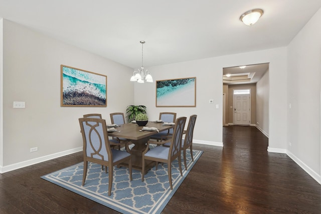 dining space with dark hardwood / wood-style floors and a chandelier