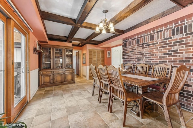 dining room featuring a chandelier, brick wall, beamed ceiling, and coffered ceiling