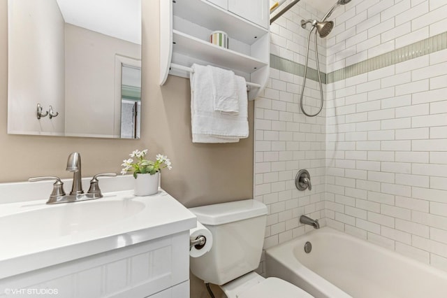 full bathroom featuring toilet, tiled shower / bath, and vanity