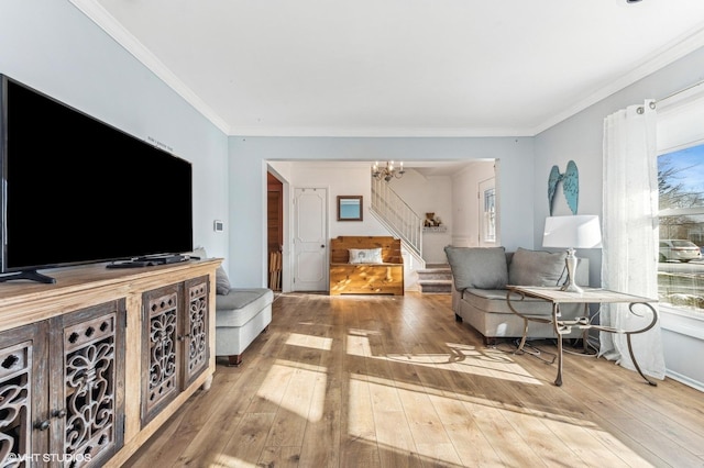 living room featuring light hardwood / wood-style flooring, crown molding, and an inviting chandelier