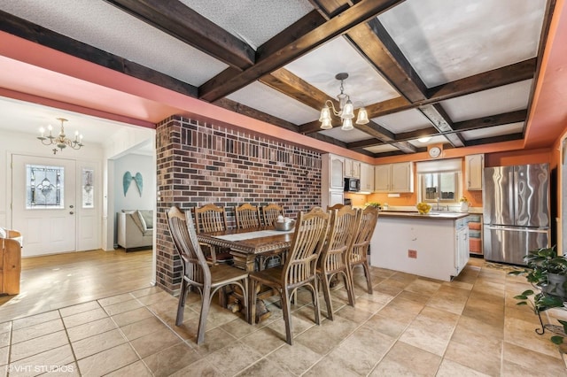 tiled dining room with beam ceiling, sink, brick wall, and an inviting chandelier