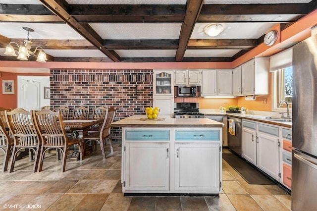 kitchen with decorative light fixtures, a notable chandelier, a center island, white cabinetry, and stainless steel appliances