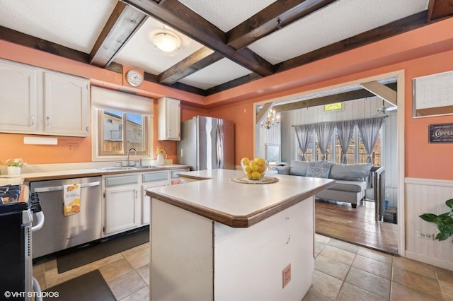 kitchen featuring a center island, sink, stainless steel appliances, white cabinets, and a chandelier