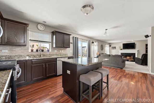 kitchen with appliances with stainless steel finishes, a center island, decorative backsplash, sink, and a breakfast bar