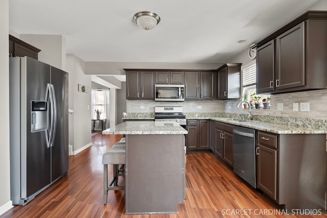 kitchen with backsplash, a center island, dark wood-type flooring, and stainless steel appliances