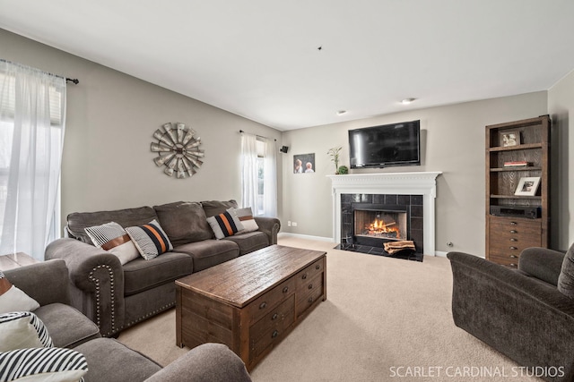 carpeted living room with a tiled fireplace