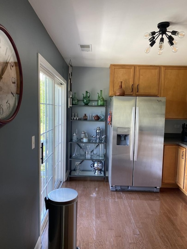 kitchen featuring wood-type flooring and stainless steel fridge