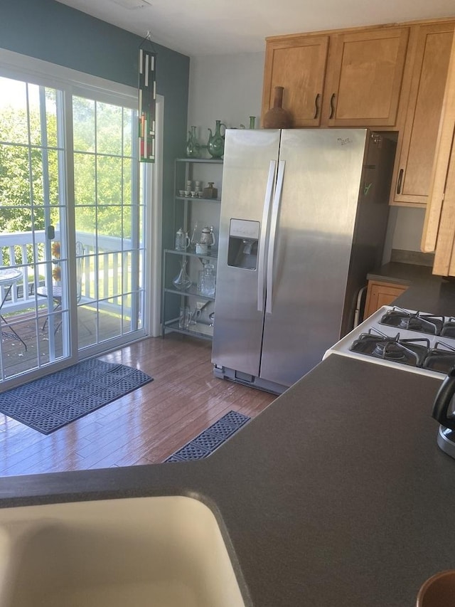 kitchen with stainless steel refrigerator with ice dispenser and wood-type flooring