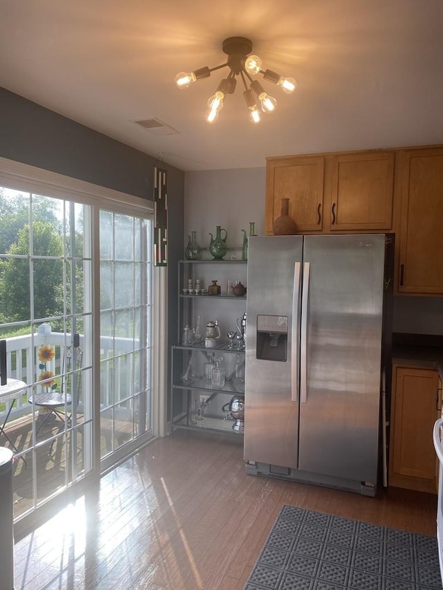 kitchen featuring wood-type flooring, stainless steel fridge with ice dispenser, and an inviting chandelier