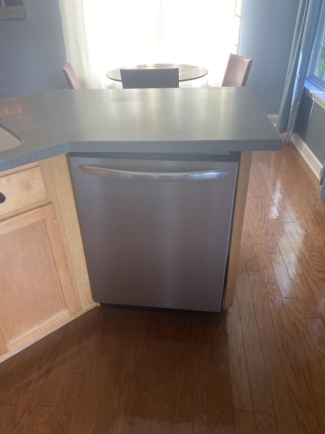 room details with dark hardwood / wood-style floors, stainless steel dishwasher, and light brown cabinets