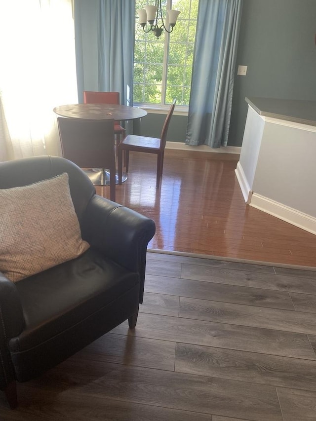 sitting room featuring wood-type flooring and a notable chandelier