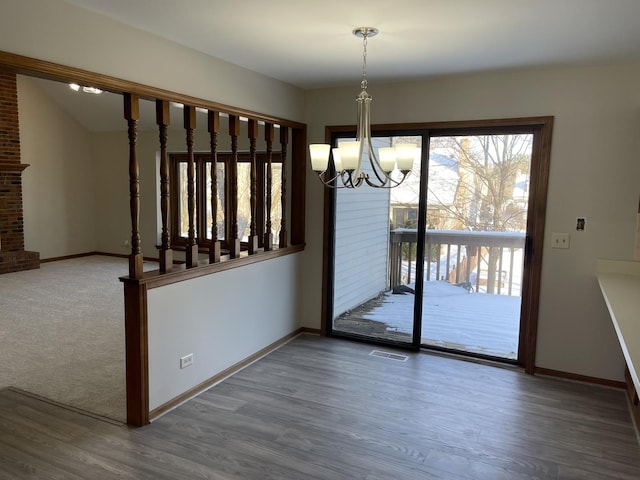 unfurnished dining area featuring hardwood / wood-style floors and a chandelier