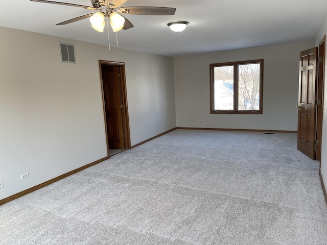 carpeted spare room featuring ceiling fan