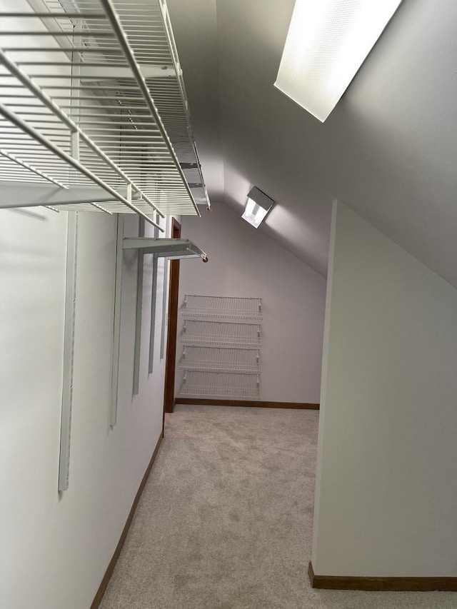 spacious closet featuring vaulted ceiling and light carpet