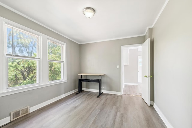 empty room with ornamental molding and light hardwood / wood-style flooring