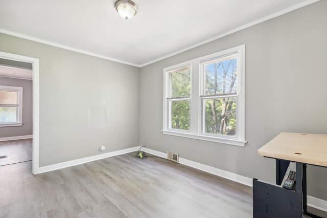 empty room with light wood-type flooring and ornamental molding