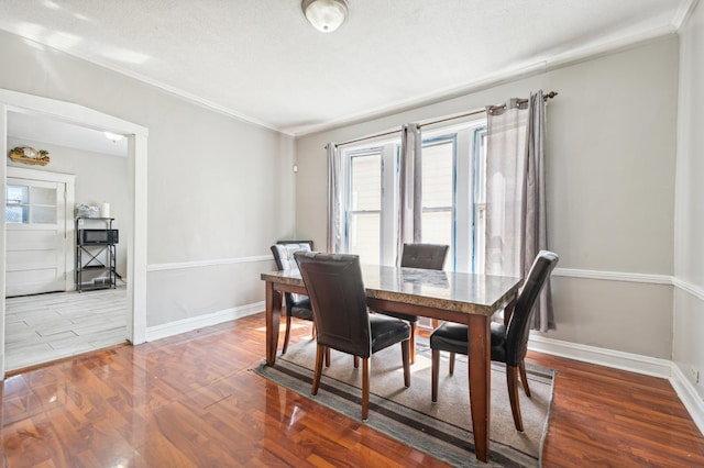 dining room featuring a textured ceiling, crown molding, and wood-type flooring