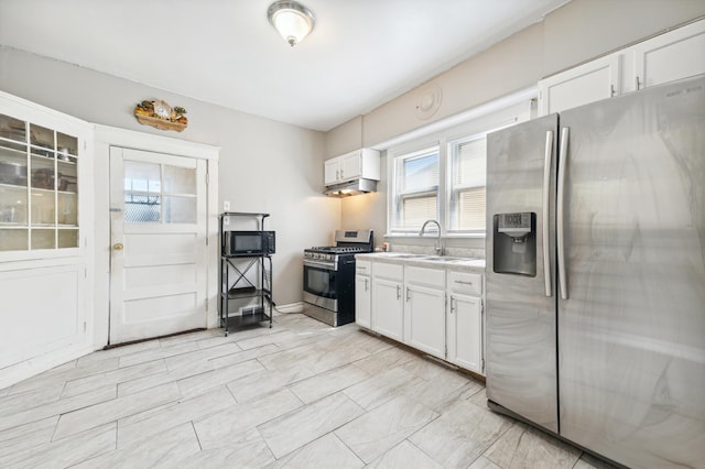 kitchen with appliances with stainless steel finishes, white cabinetry, and sink