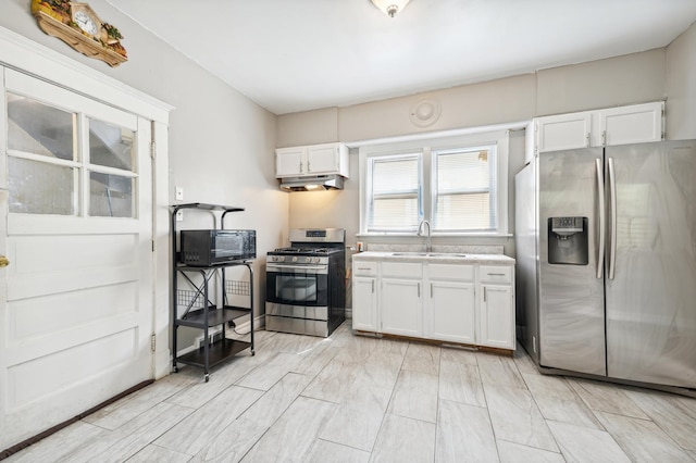 kitchen featuring stainless steel appliances, white cabinetry, and sink