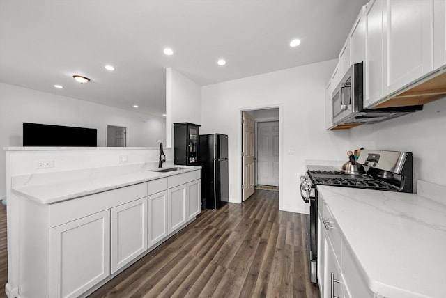 kitchen with sink, dark wood-type flooring, appliances with stainless steel finishes, and white cabinetry