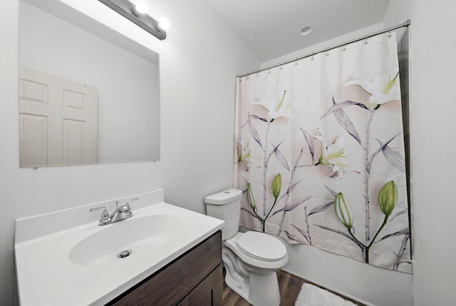 full bathroom featuring wood-type flooring, shower / tub combo, vanity, and toilet