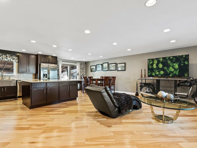 living room featuring sink and light hardwood / wood-style flooring