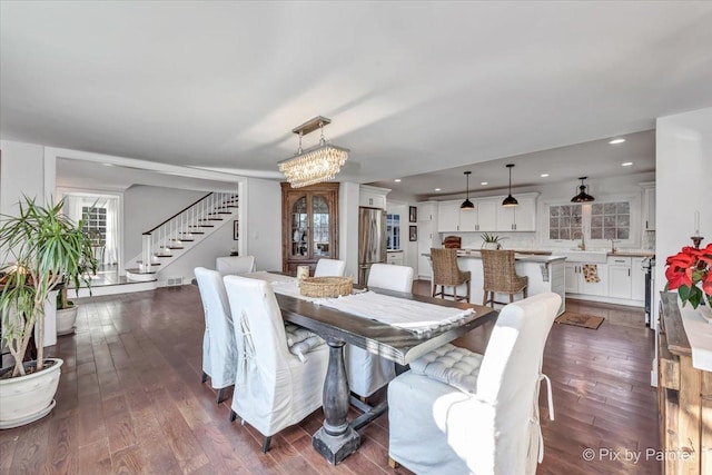 dining space featuring visible vents, stairway, dark wood-type flooring, an inviting chandelier, and recessed lighting