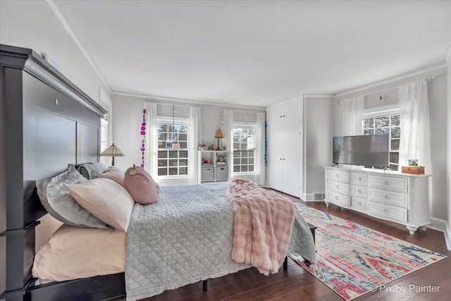 bedroom featuring visible vents, ornamental molding, and wood finished floors