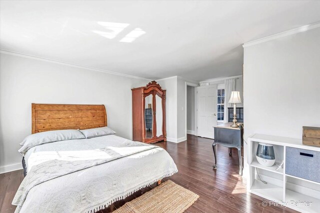 bedroom featuring crown molding, baseboards, and wood finished floors