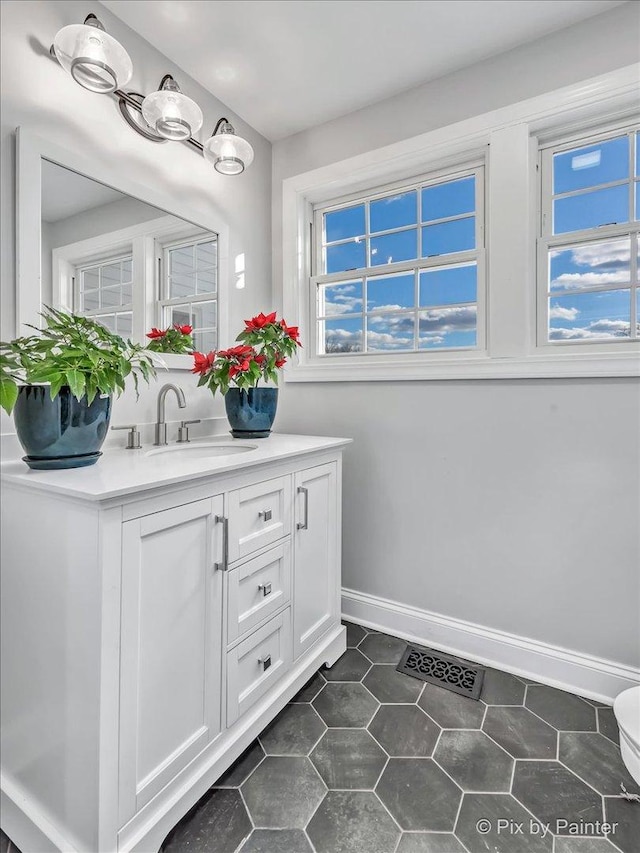 bathroom featuring visible vents, vanity, baseboards, and tile patterned floors