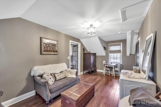 living area featuring lofted ceiling, dark wood-style floors, attic access, and baseboards