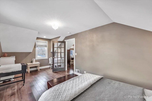 bedroom featuring baseboards, visible vents, lofted ceiling, wood finished floors, and french doors