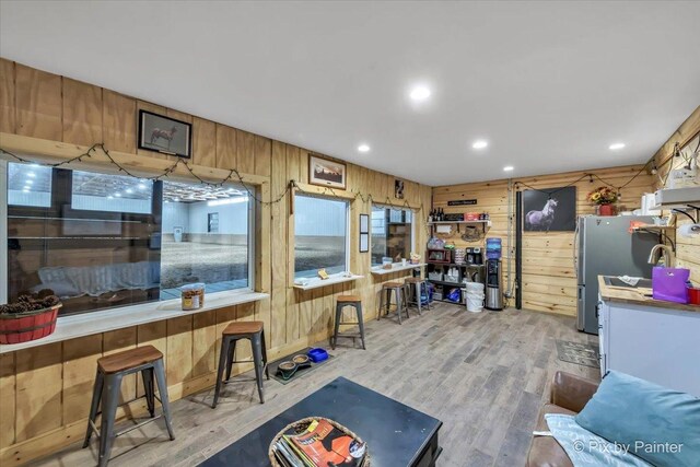 interior space with recessed lighting, light wood-style flooring, and wooden walls