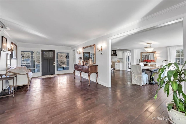 living area featuring crown molding, baseboards, and wood finished floors