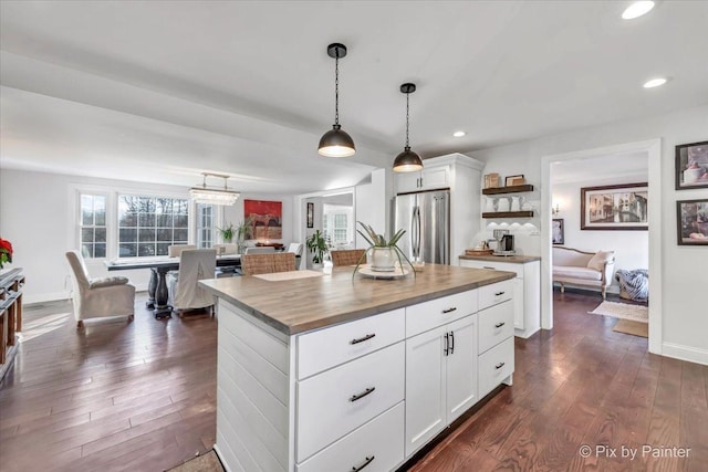 kitchen with pendant lighting, wooden counters, dark wood-type flooring, and freestanding refrigerator