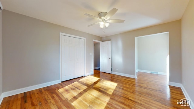 unfurnished bedroom with ceiling fan, light hardwood / wood-style flooring, and a closet