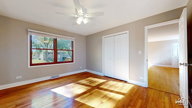 unfurnished bedroom with ceiling fan, light hardwood / wood-style flooring, and a closet