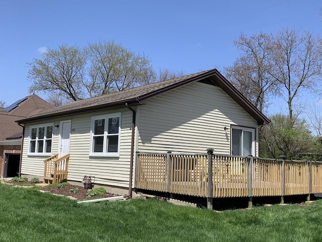 view of side of property with a deck and a yard