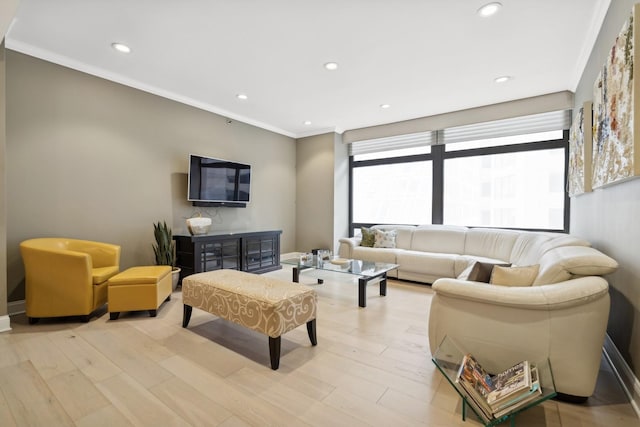 living room with ornamental molding and light hardwood / wood-style floors