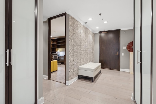 hall featuring crown molding and light hardwood / wood-style floors